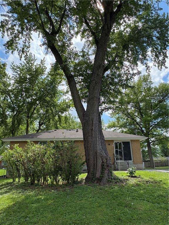 exterior space with a yard, brick siding, and fence