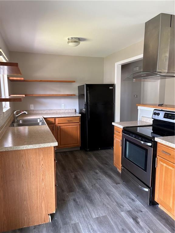 kitchen featuring a sink, freestanding refrigerator, island range hood, stainless steel electric stove, and dark wood-style floors