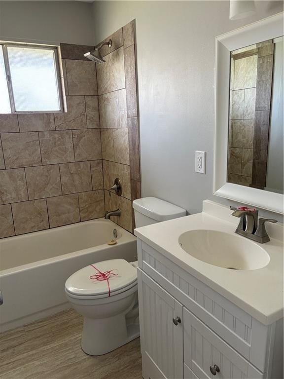 full bath featuring vanity, washtub / shower combination, wood finished floors, and toilet