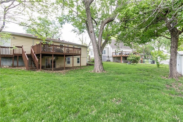 view of yard with fence, a wooden deck, and stairs