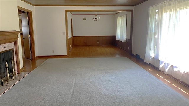 109 N 2nd St, Hiawatha, KS 66434 - unfurnished living room with plenty of natural light, a premium fireplace, a chandelier, a wainscoted wall, and carpet flooring