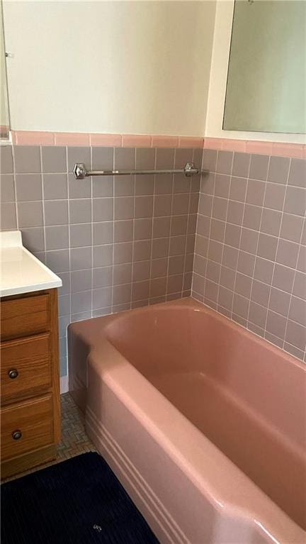 109 N 2nd St, Hiawatha, KS 66434 - bathroom with a bathtub, tile walls, vanity, and a wainscoted wall