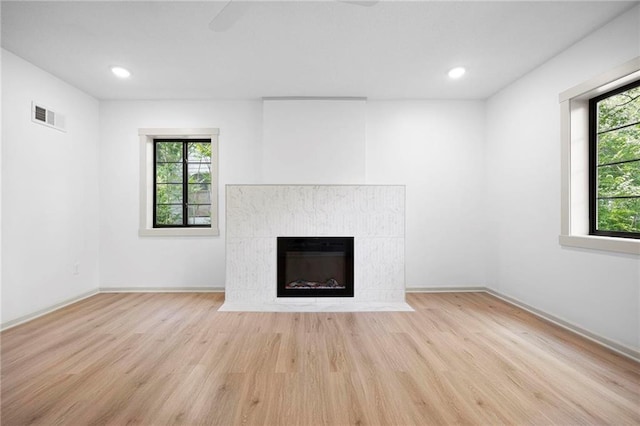 1639 Indiana St, Lawrence, KS 66044 - unfurnished living room featuring wood finished floors, a premium fireplace, baseboards, and recessed lighting