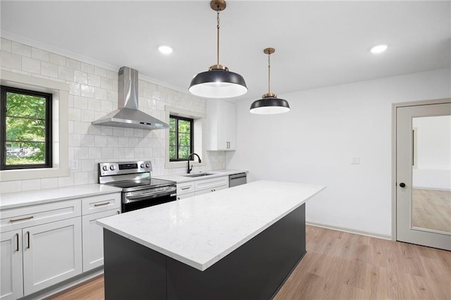 1639 Indiana St, Lawrence, KS 66044 - kitchen featuring appliances with stainless steel finishes, wall chimney range hood, a sink, tasteful backsplash, and light wood-type flooring