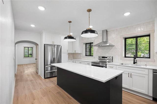 1639 Indiana St, Lawrence, KS 66044 - kitchen featuring stainless steel appliances, wall chimney range hood, a sink, a kitchen island, and light countertops