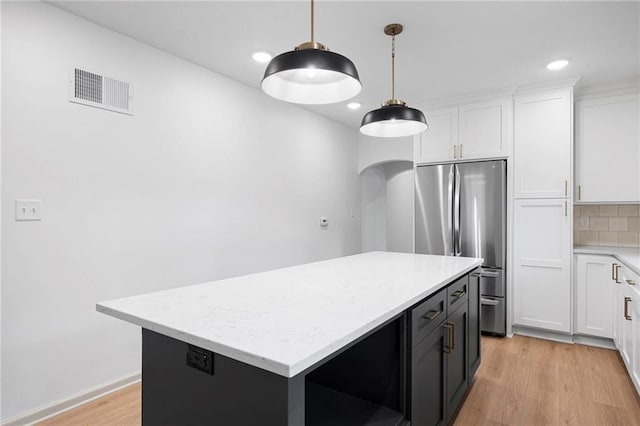 1639 Indiana St, Lawrence, KS 66044 - kitchen featuring freestanding refrigerator, light wood-style flooring, white cabinets, and recessed lighting