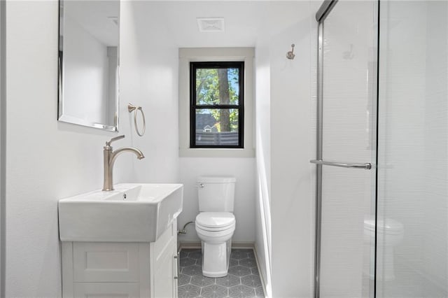1639 Indiana St, Lawrence, KS 66044 - bathroom featuring toilet, a stall shower, vanity, and baseboards