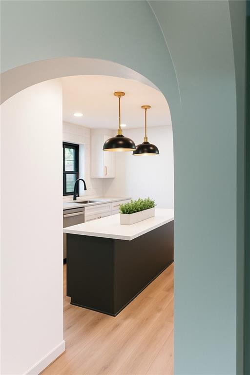 1639 Indiana St, Lawrence, KS 66044 - kitchen with a sink, light countertops, light wood-type flooring, and white cabinetry