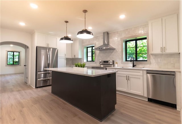 1639 Indiana St, Lawrence, KS 66044 - kitchen featuring appliances with stainless steel finishes, wall chimney exhaust hood, a sink, light countertops, and decorative backsplash