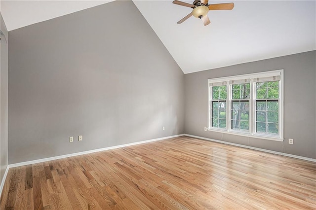 empty room with vaulted ceiling, ceiling fan, light wood-type flooring, and baseboards