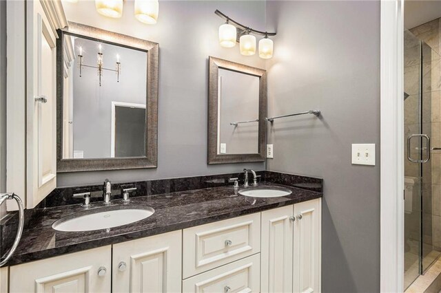 bathroom featuring a stall shower and double vanity