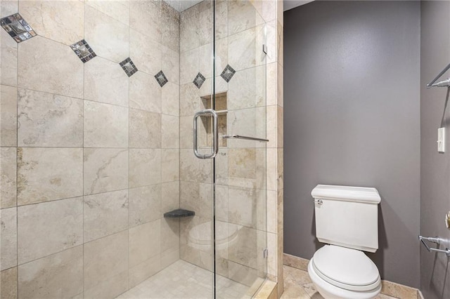 full bathroom featuring a shower stall, toilet, and baseboards
