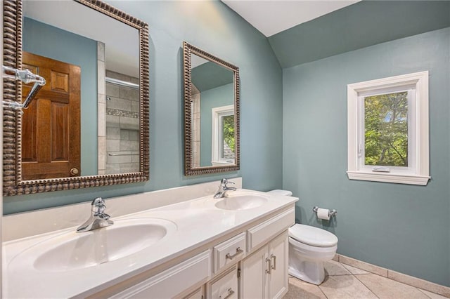 bathroom with toilet, tile patterned floors, double vanity, vaulted ceiling, and baseboards