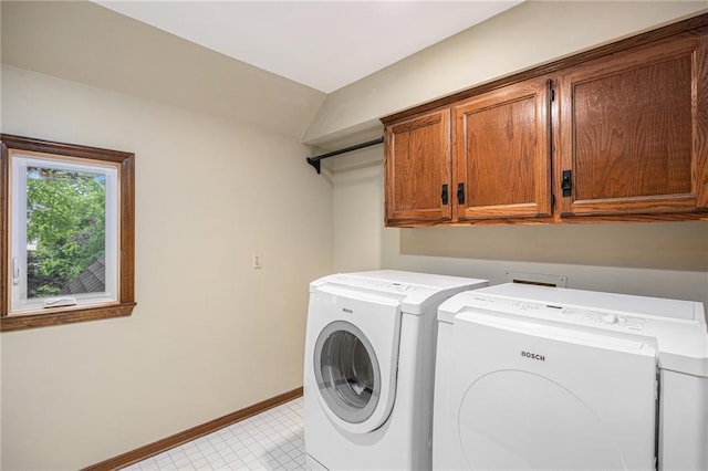 laundry area with cabinet space, washing machine and dryer, and baseboards