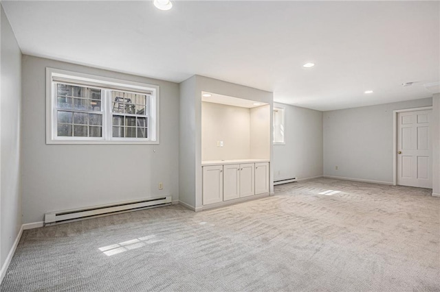 unfurnished room with a baseboard radiator, light carpet, recessed lighting, and baseboards