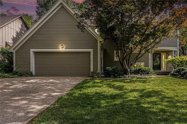 view of front of property with concrete driveway, an attached garage, board and batten siding, and a yard