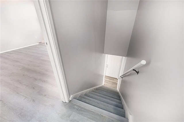 stairs with baseboards and wood finished floors