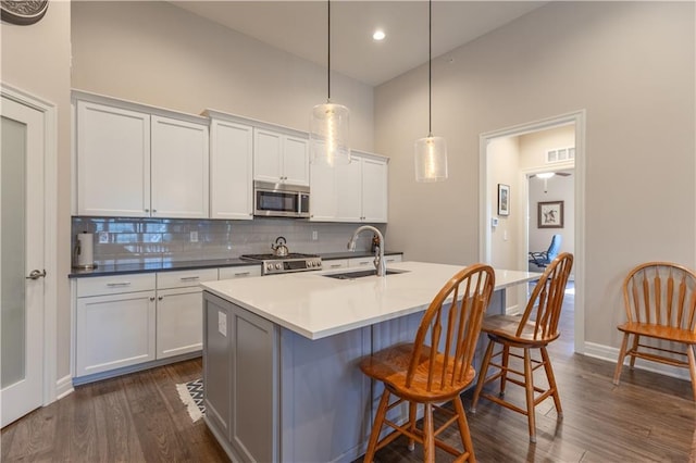 6529 Barth Rd, Shawnee, KS 66226 - kitchen with stainless steel microwave, range, a sink, tasteful backsplash, and dark wood finished floors
