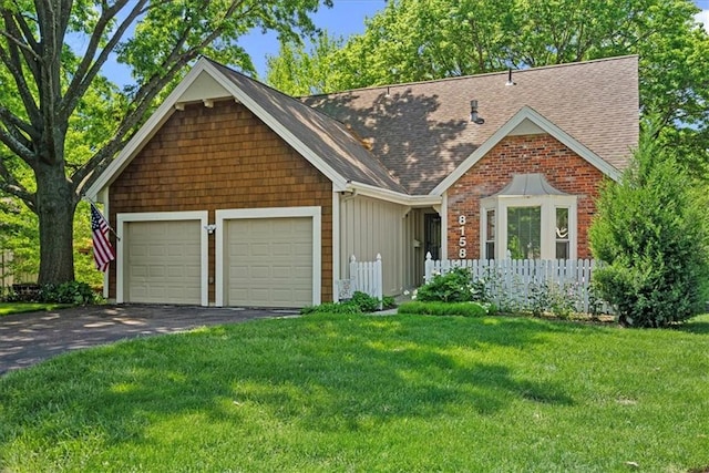 view of front facade featuring a garage, roof with shingles, a front yard, asphalt driveway, and board and batten siding