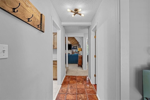 corridor with a textured ceiling and baseboards