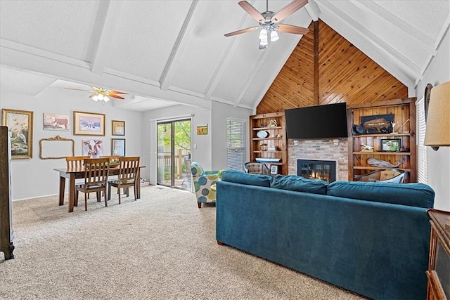 carpeted living room with ceiling fan, a fireplace, wood walls, beam ceiling, and high vaulted ceiling