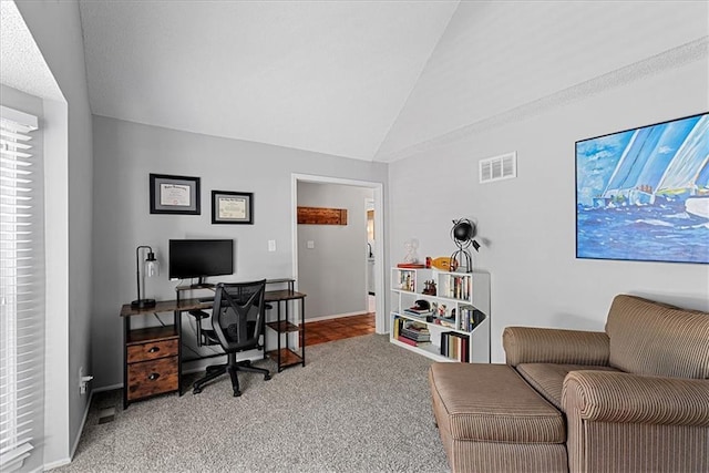 office featuring lofted ceiling, light carpet, and baseboards