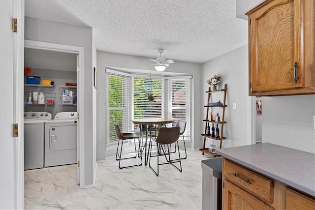 8158 Monrovia St, Lenexa, KS 66215 - dining space with light marble finish floors, separate washer and dryer, a ceiling fan, and a textured ceiling