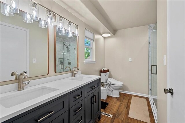 8158 Monrovia St, Lenexa, KS 66215 - bathroom with toilet, a shower stall, wood finished floors, double vanity, and baseboards