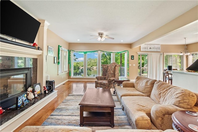 14 Emerald Shore Dr, Lake Tapawingo, MO 64015 - living room featuring a fireplace, wood finished floors, ceiling fan, baseboards, and healthy amount of natural light