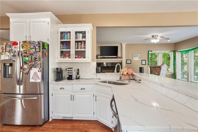 14 Emerald Shore Dr, Lake Tapawingo, MO 64015 - kitchen with stainless steel fridge, a sink, light stone counters, decorative backsplash, and white cabinetry