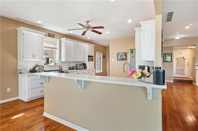 14 Emerald Shore Dr, Lake Tapawingo, MO 64015 - kitchen featuring a breakfast bar area, a peninsula, white cabinets, ceiling fan, and recessed lighting