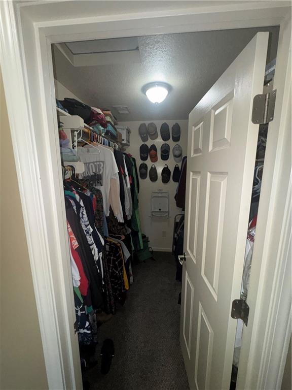14 Emerald Shore Dr, Lake Tapawingo, MO 64015 - walk in closet featuring dark colored carpet