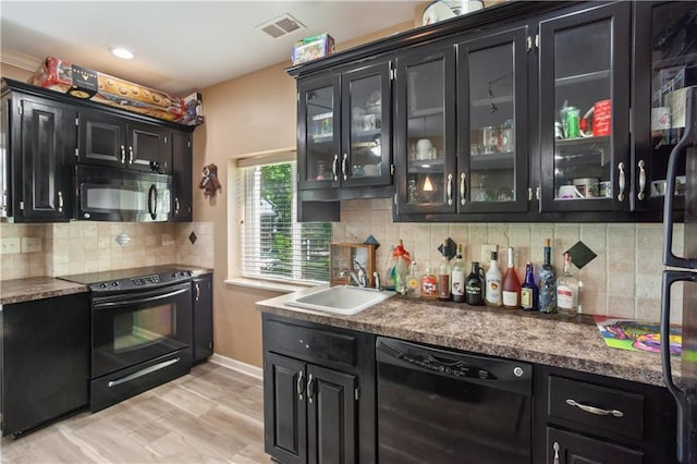 14 Emerald Shore Dr, Lake Tapawingo, MO 64015 - kitchen featuring black appliances, dark cabinetry, a sink, decorative backsplash, and glass insert cabinets