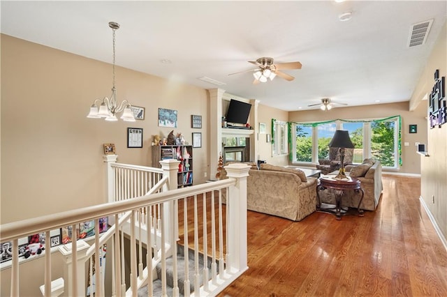 14 Emerald Shore Dr, Lake Tapawingo, MO 64015 - living area featuring a ceiling fan, wood finished floors, a glass covered fireplace, and a chandelier