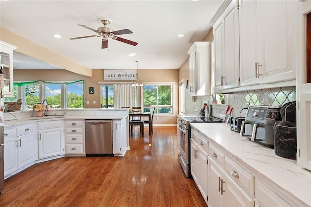 14 Emerald Shore Dr, Lake Tapawingo, MO 64015 - kitchen with stainless steel appliances, ceiling fan, white cabinetry, wood finished floors, and tasteful backsplash