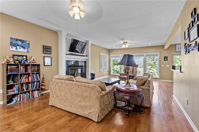 14 Emerald Shore Dr, Lake Tapawingo, MO 64015 - living room featuring a ceiling fan, wood finished floors, a fireplace, and a textured ceiling