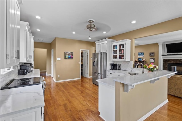 14 Emerald Shore Dr, Lake Tapawingo, MO 64015 - kitchen with stainless steel fridge with ice dispenser, ceiling fan, a peninsula, tasteful backsplash, and light wood finished floors