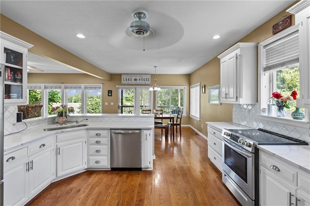 14 Emerald Shore Dr, Lake Tapawingo, MO 64015 - kitchen featuring appliances with stainless steel finishes, ceiling fan, decorative backsplash, white cabinetry, and healthy amount of natural light