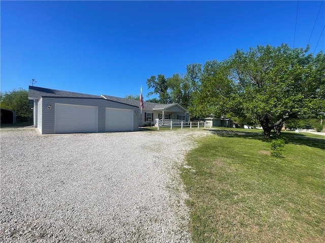 single story home with a front yard, driveway, and a garage