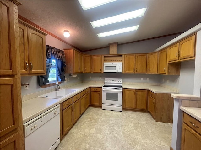 kitchen featuring brown cabinetry, white appliances, a sink, and vaulted ceiling