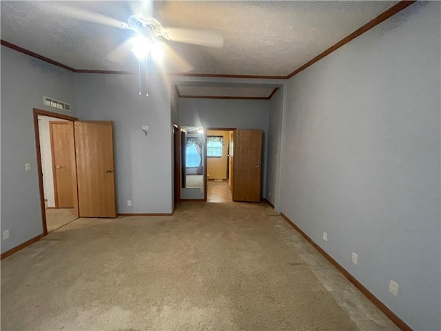 unfurnished bedroom with crown molding, a textured ceiling, and visible vents