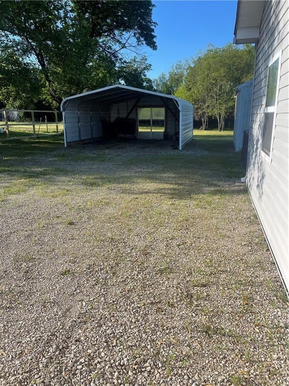 view of yard with driveway and a detached carport
