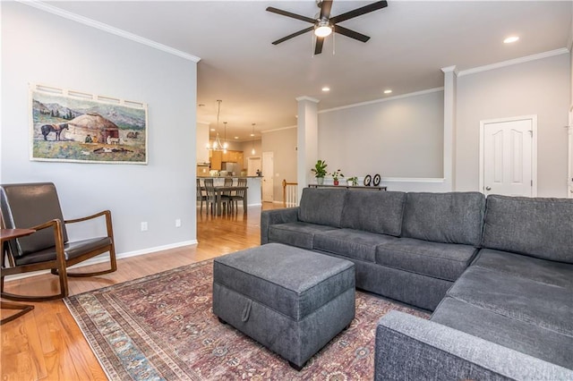 living room with a ceiling fan, wood finished floors, ornamental molding, baseboards, and recessed lighting