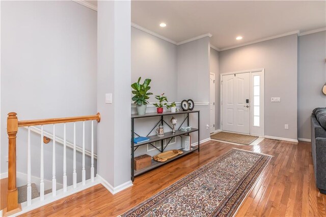 foyer entrance featuring hardwood / wood-style flooring, crown molding, recessed lighting, and baseboards