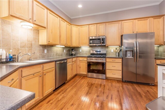 kitchen featuring stainless steel appliances, light brown cabinets, crown molding, and recessed lighting