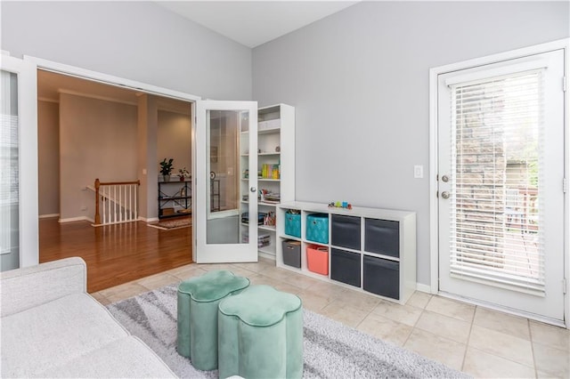 tiled living room featuring french doors, healthy amount of natural light, and baseboards