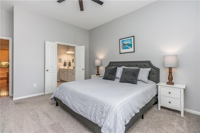carpeted bedroom featuring ensuite bath, baseboards, and ceiling fan