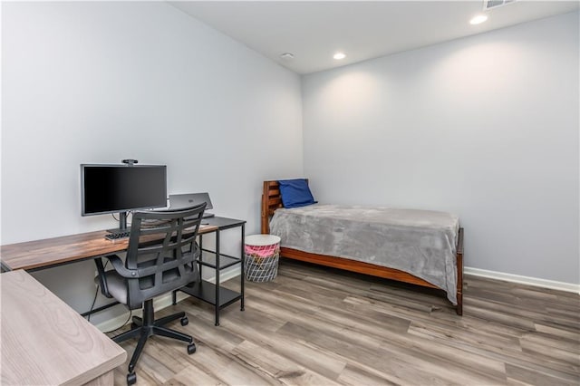 bedroom featuring wood finished floors, baseboards, an office area, and recessed lighting