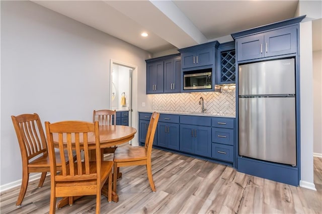 dining area featuring light wood-style floors, baseboards, and recessed lighting