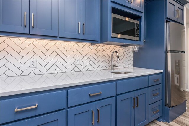kitchen featuring blue cabinetry and appliances with stainless steel finishes